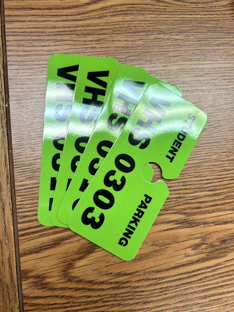 The student parking passes are bright green, and each pass number corresponds to the specific student registration.